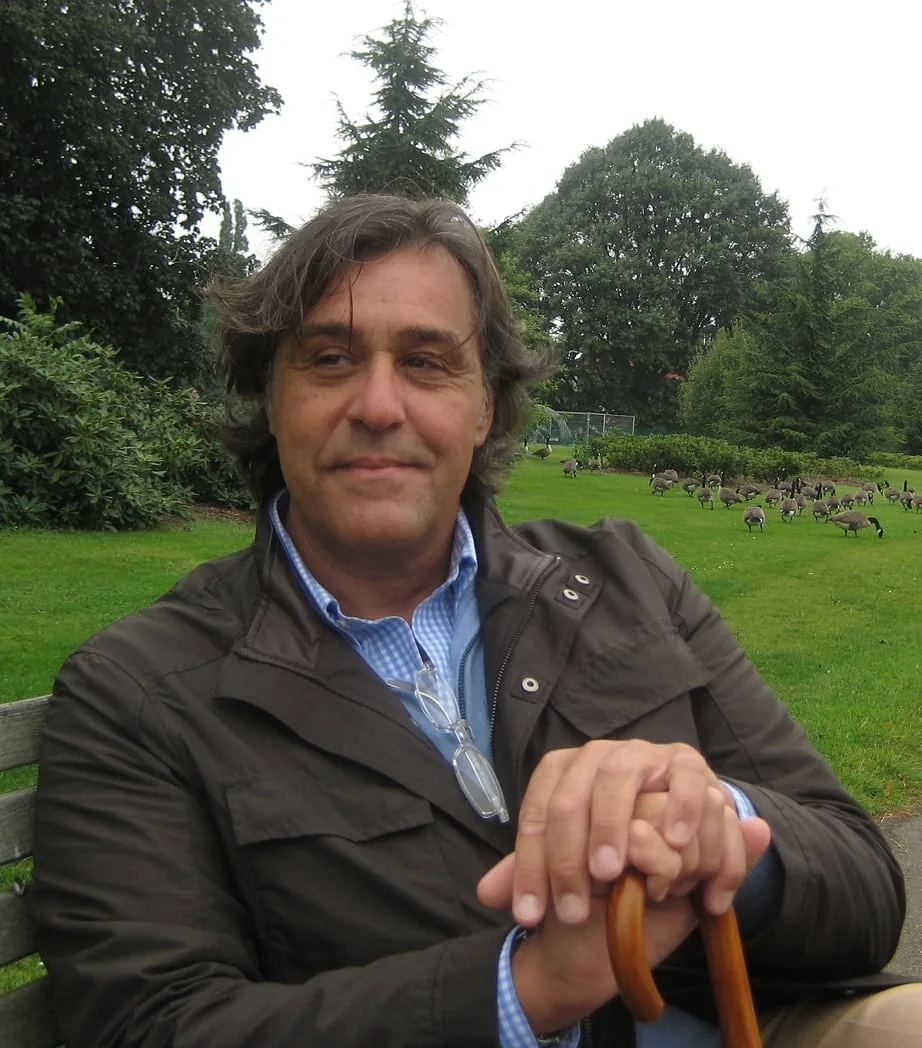 Baudilio Ruiz on a park bench, hands on a walking cane