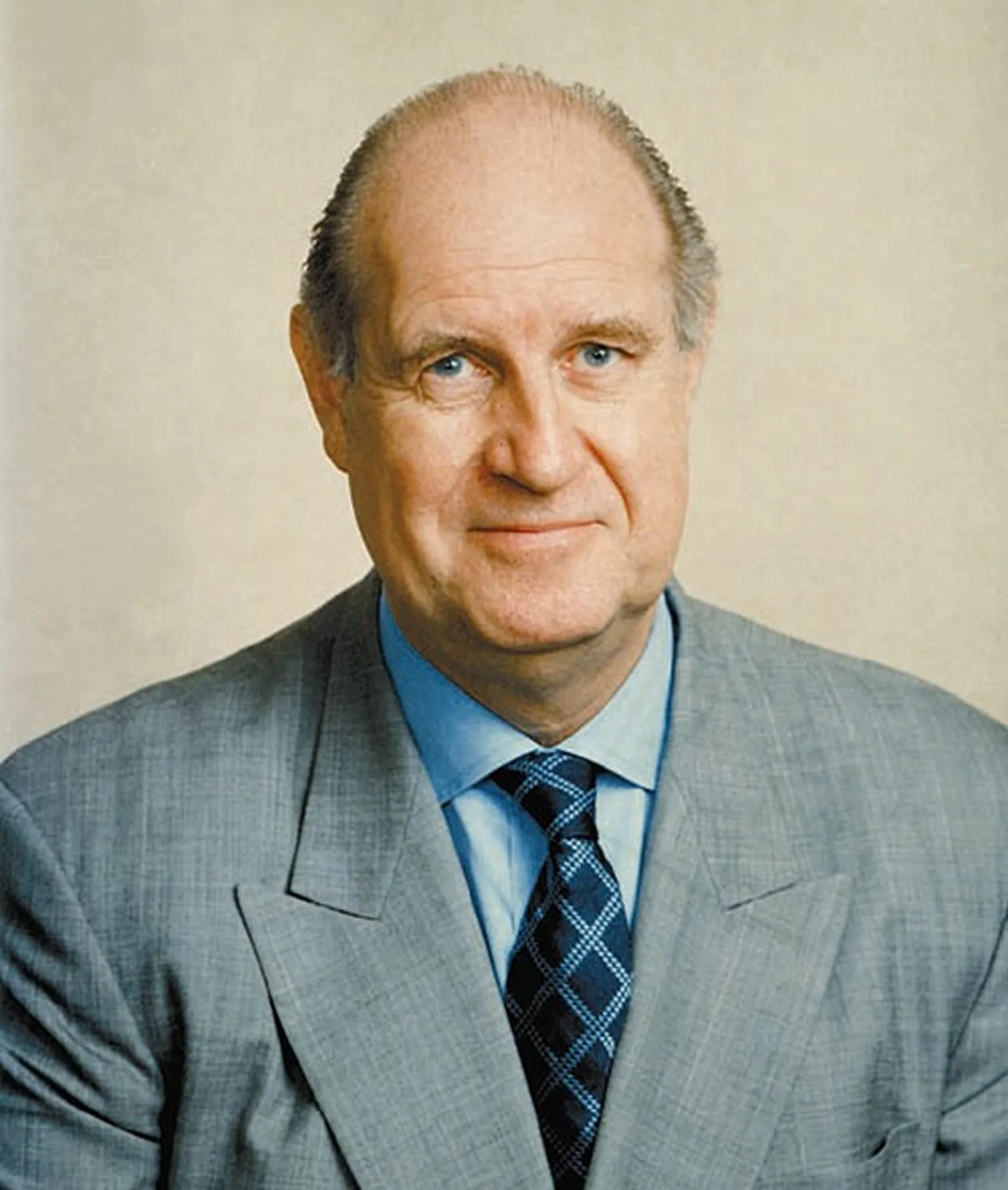 Bill Bissell, portrait in a grey suit and check tie