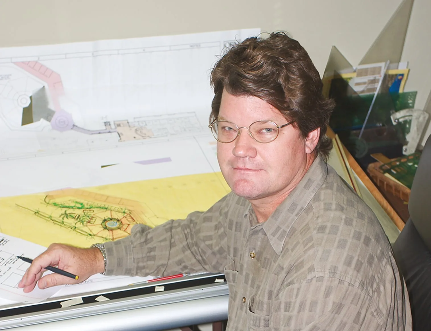 Doug Kulig at the drafting table, pen in hand over a resort plan