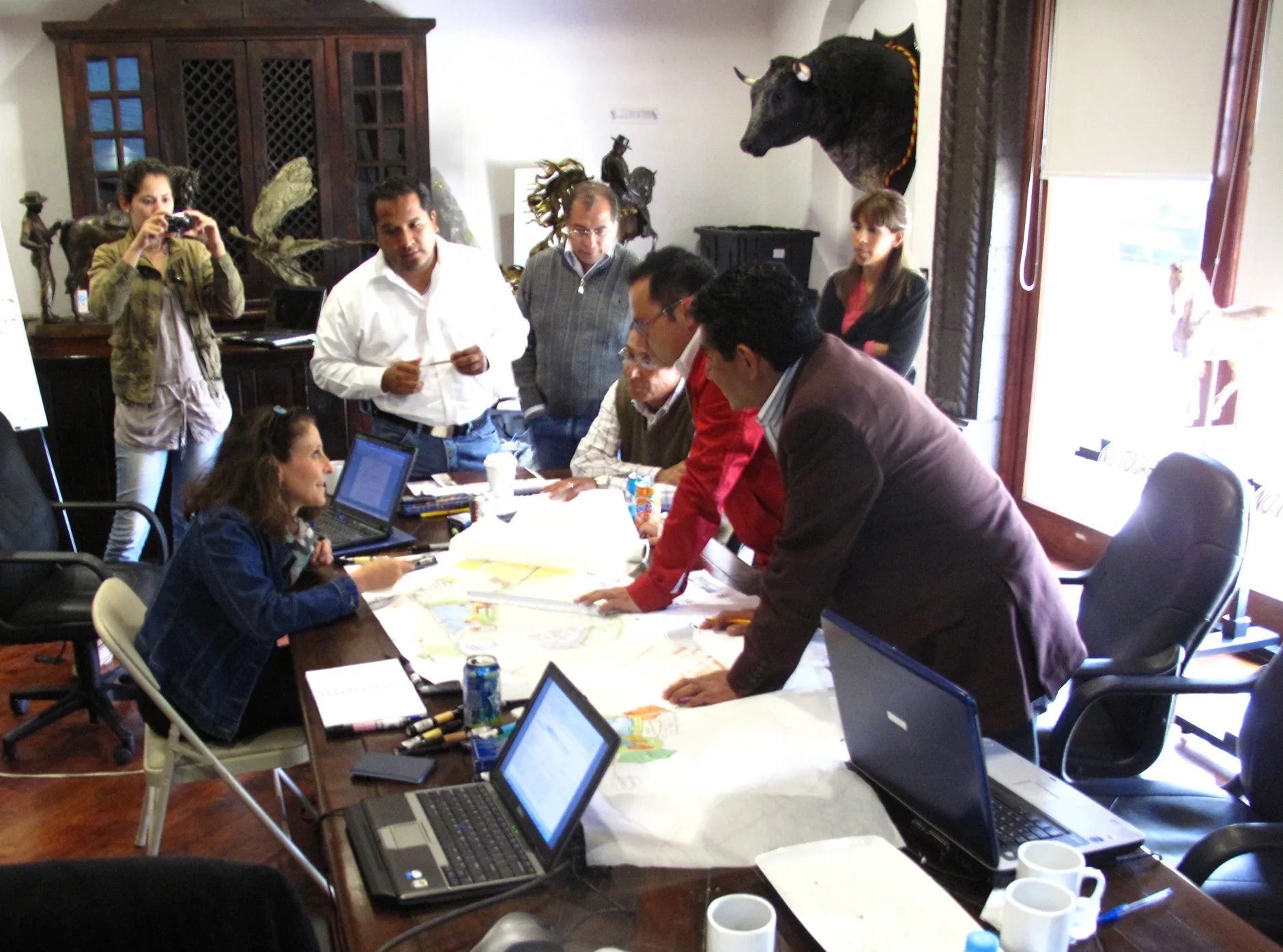 A design charrette in 2007: Liora Haymann and colleagues around a table covered in drawings and laptops