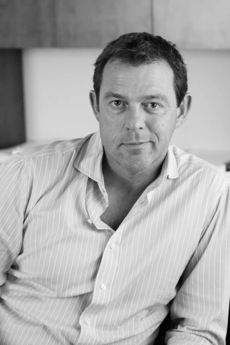 Mike Wilson in a striped open-collared shirt, a black and white portrait
