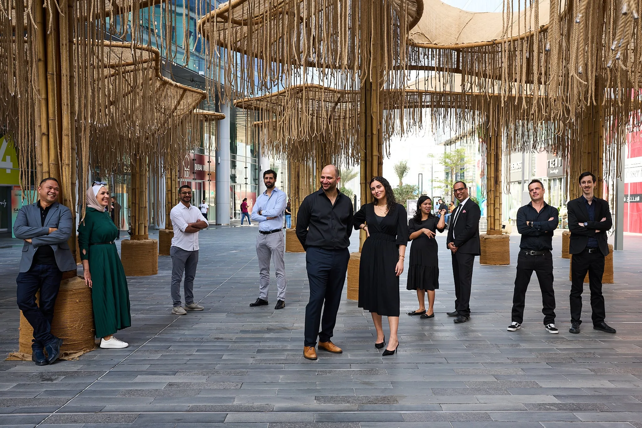 The OBMI Dubai team standing beneath the pavilion's hanging ropes