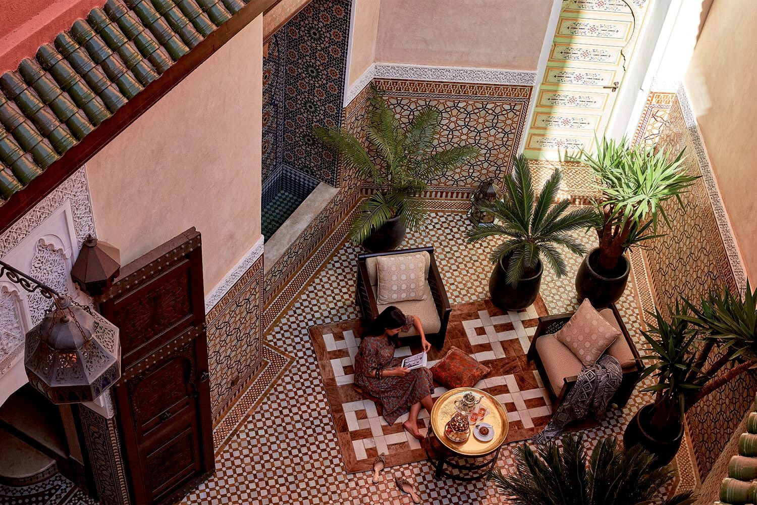 A woman reading inside a Riad Courtyard in Royal Mansour