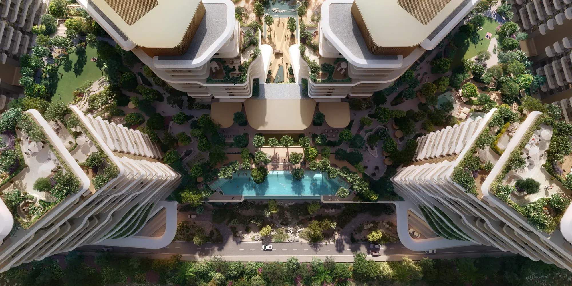The community from directly above: towers and low blocks around a green spine with a pool at its centre