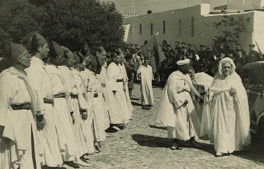 Sepia photograph of a ceremony in Tangier, men in white robes in a line