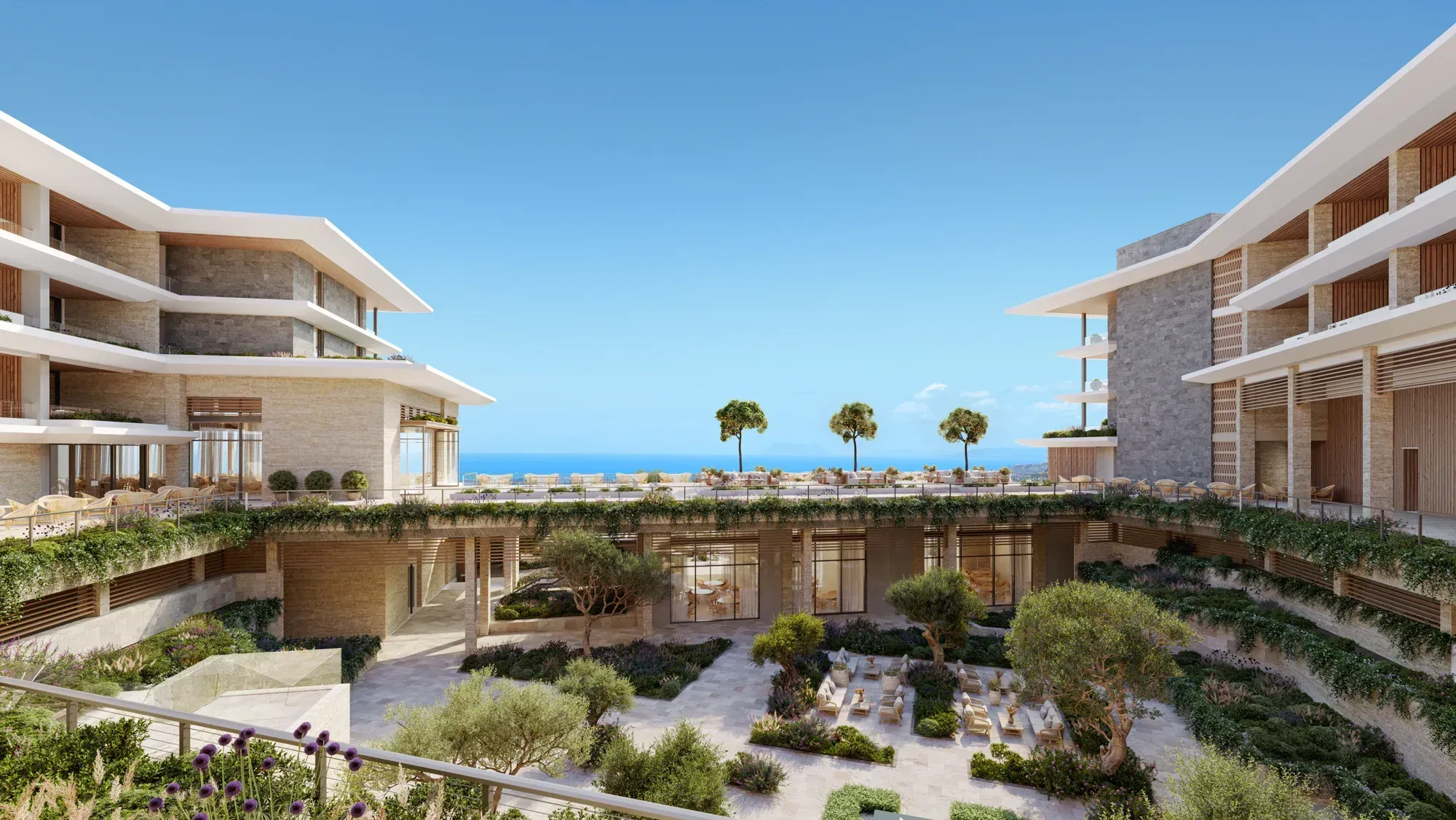 A courtyard of olive trees between two wings, the sea beyond the far terrace
