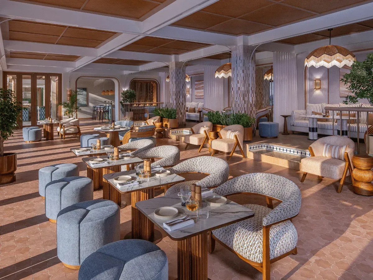The dining room at evening: rattan chairs around a table, fringed pendants, the sunset in the mirror