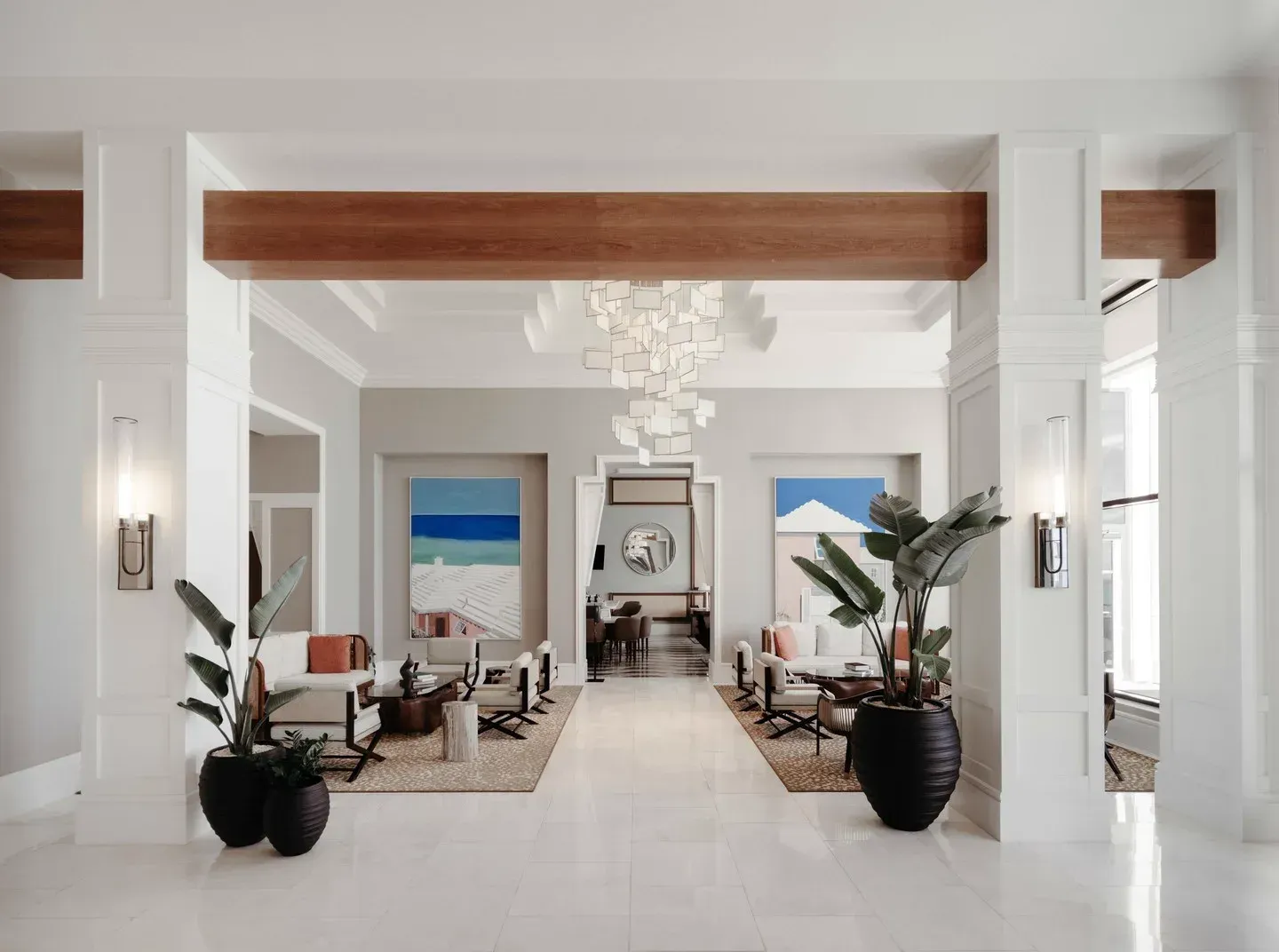 The Great Hall: a cedar beam over white columns, a paper chandelier, paintings of the shore