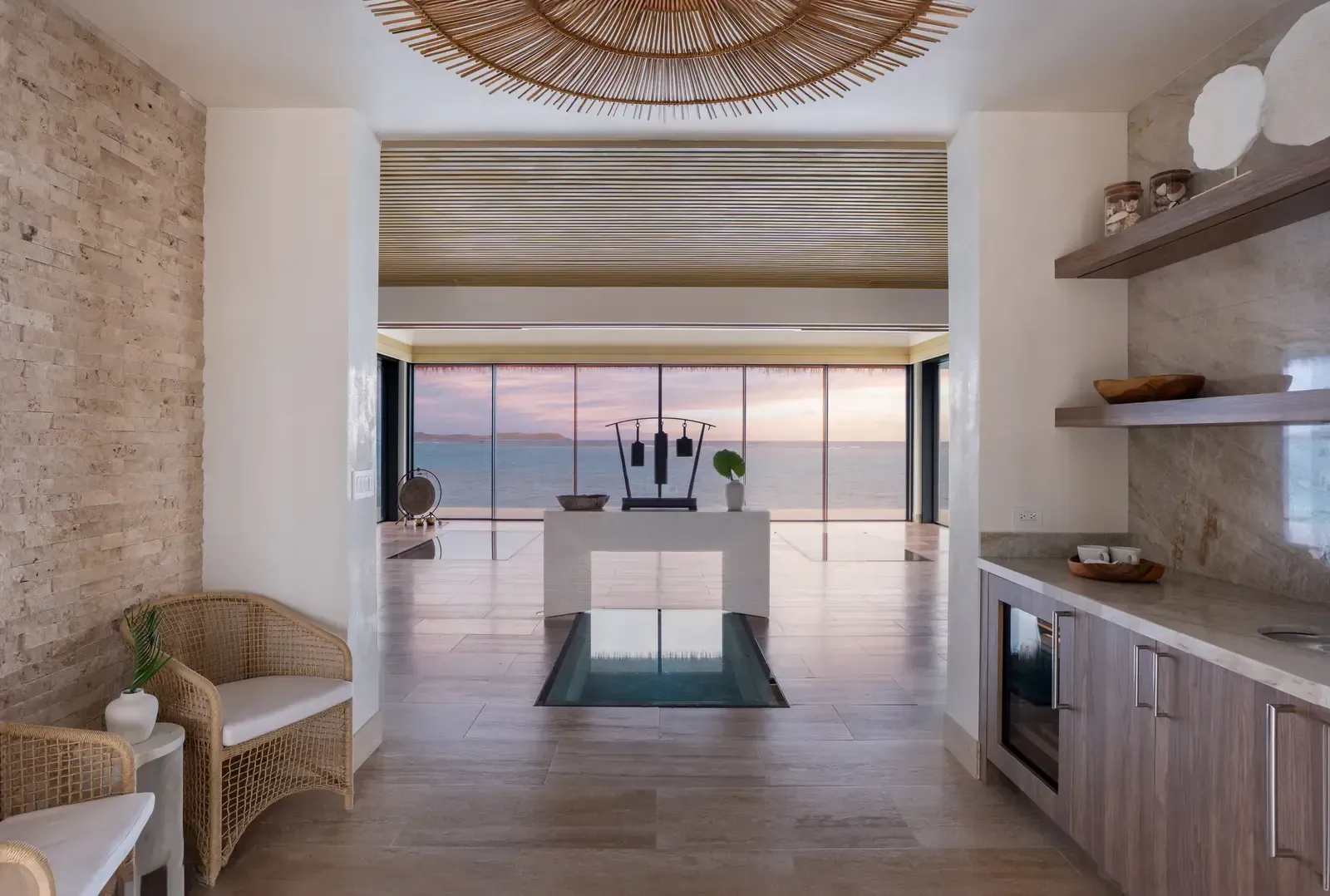 The lobby at dusk, the sky pink through the glazing, the glass floor lit from below