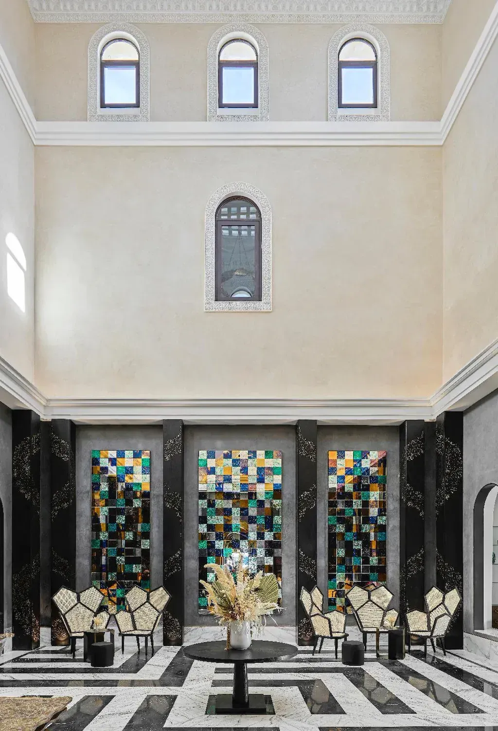 The palace foyer: high plaster walls with arched windows over panels of coloured glass tiles