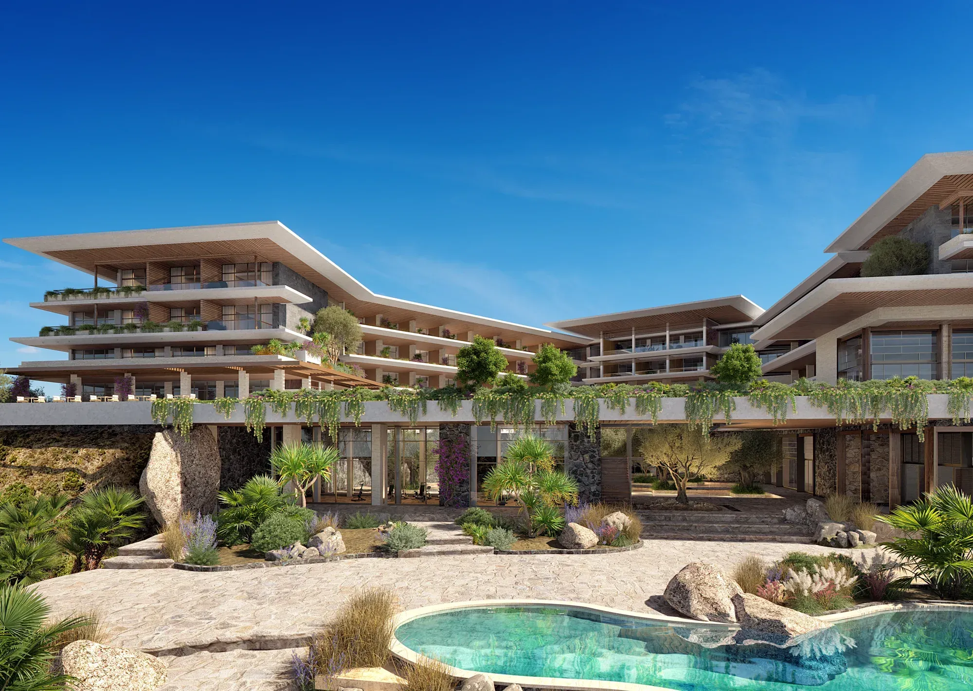The stepped buildings above a rock-edged pool, gardens trailing from the terraces