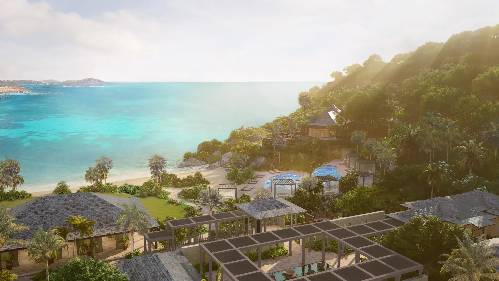 The spa pavilions on the hillside, the pools and the beach below at dusk