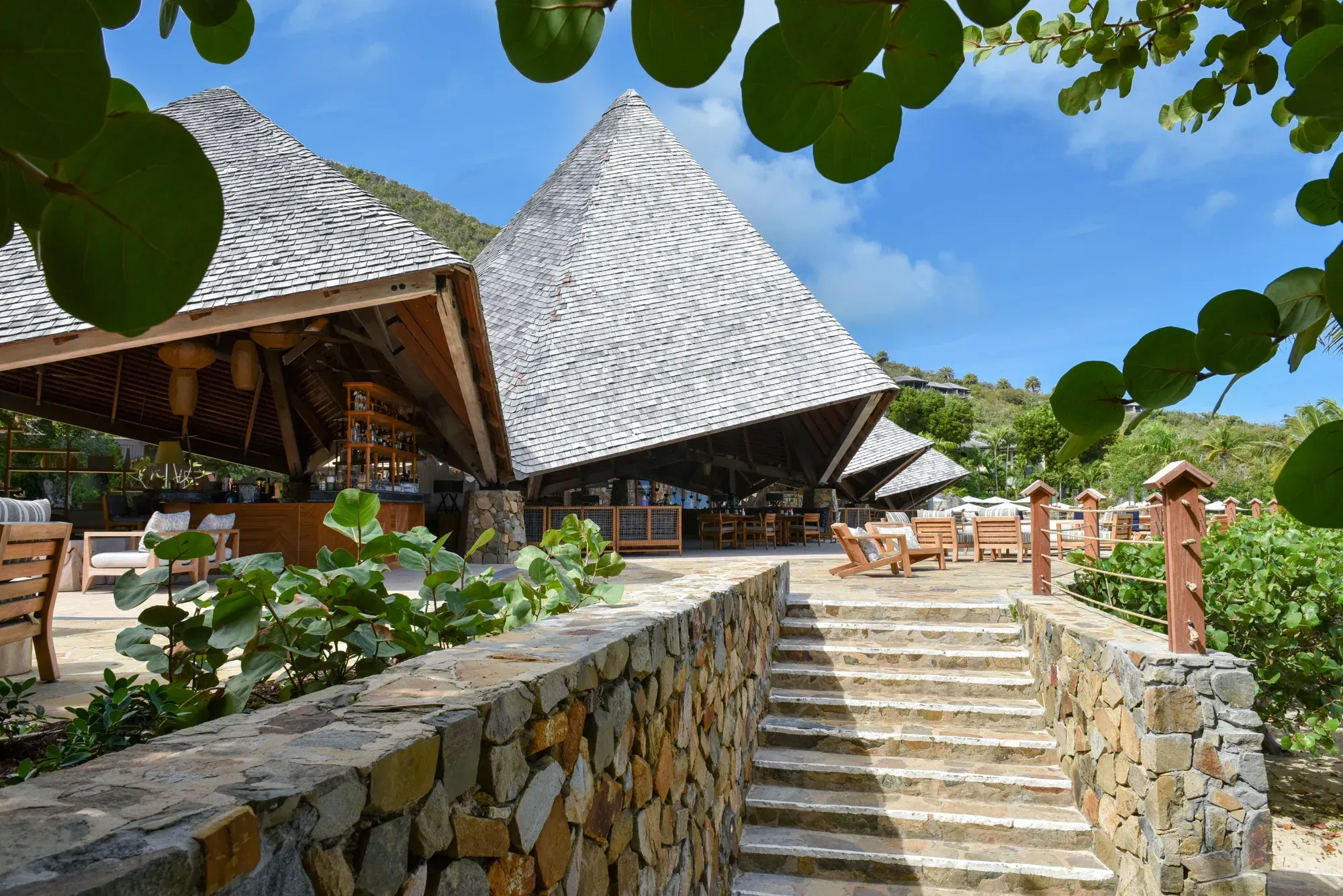 Stone steps between walls up to the pavilions, sea grape leaves overhead
