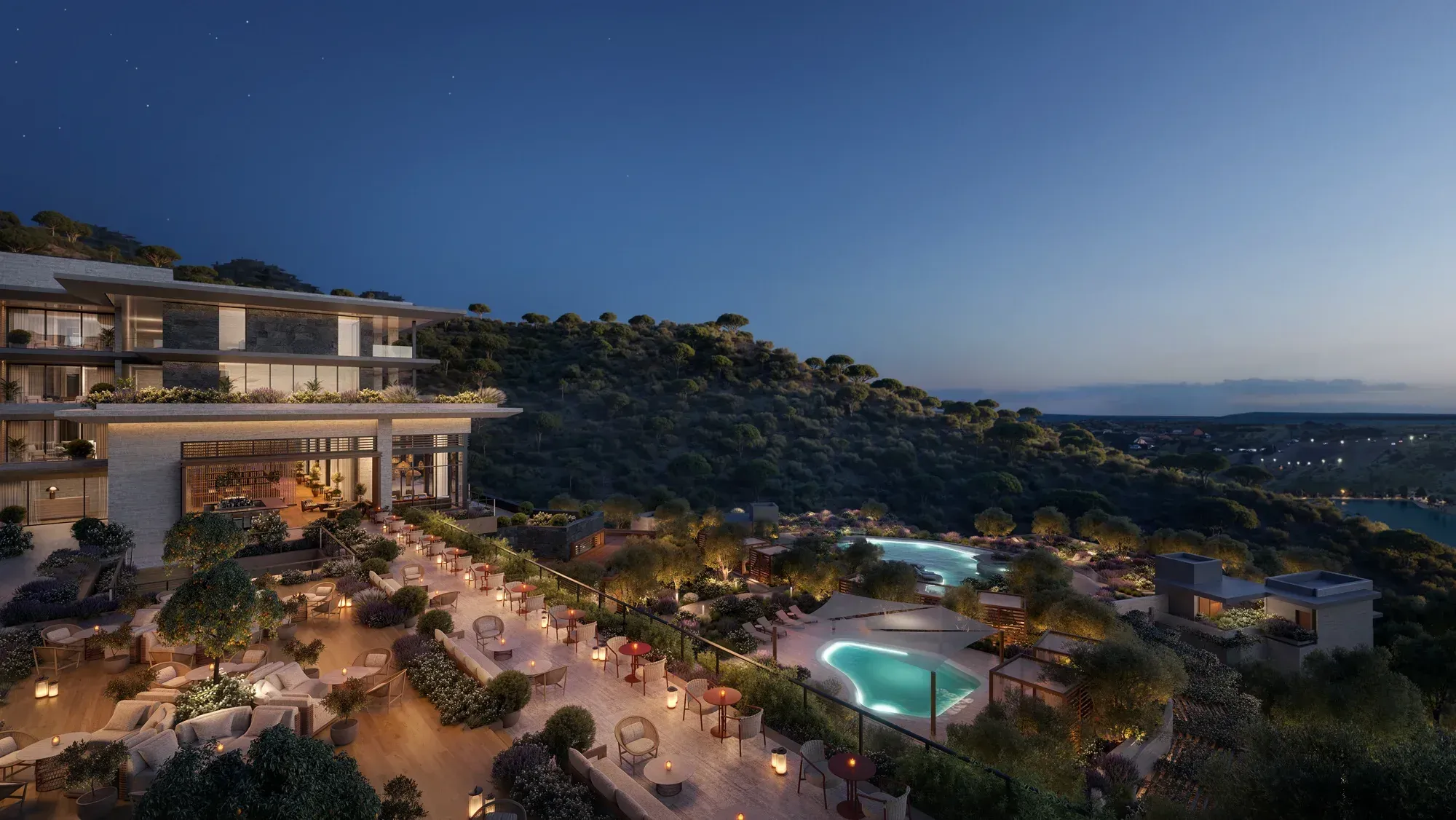 The restaurant terrace at night, lit pools on the hillside below, the lake in the distance