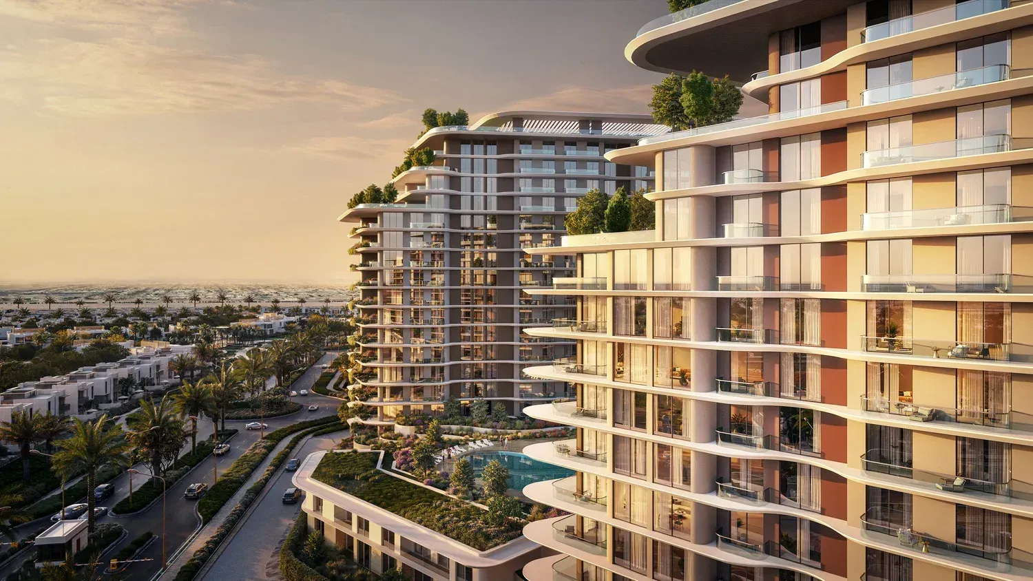 Curved balconies stepping up the towers at sunset, the low villas of the community beyond